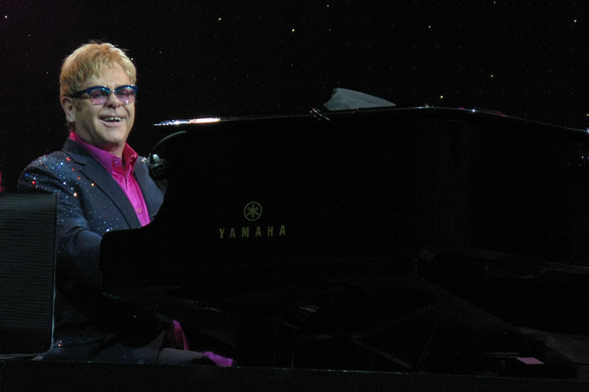 Elton John behind his piano in 2013